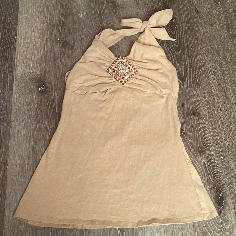 beige colored shirt. beaded in the middle